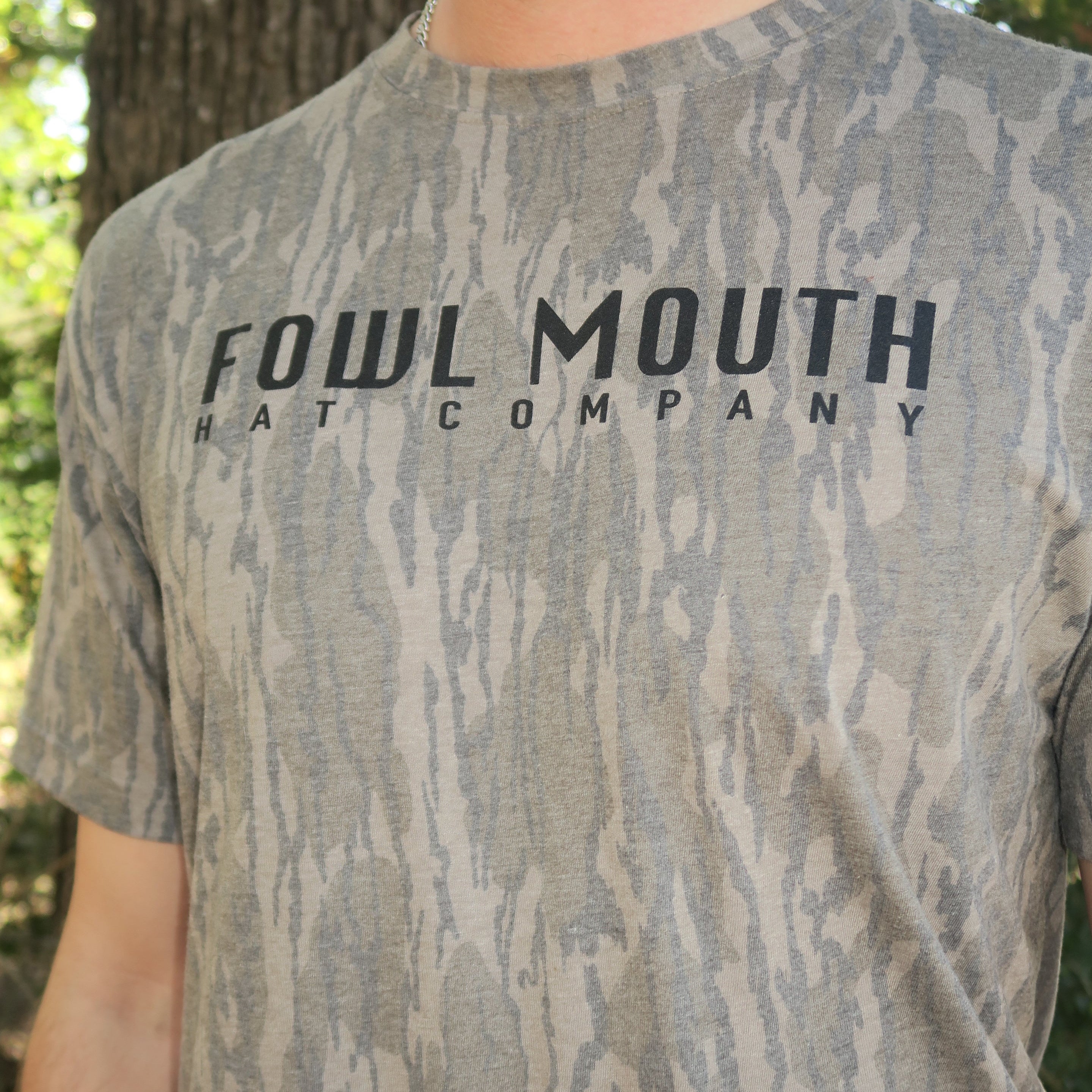 Person wearing a gray camouflage t-shirt with 'Foul Mouth' branding.